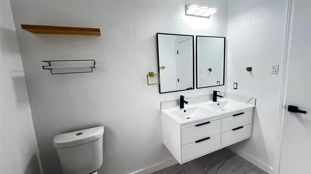 a bathroom with a toilet sink and mirror