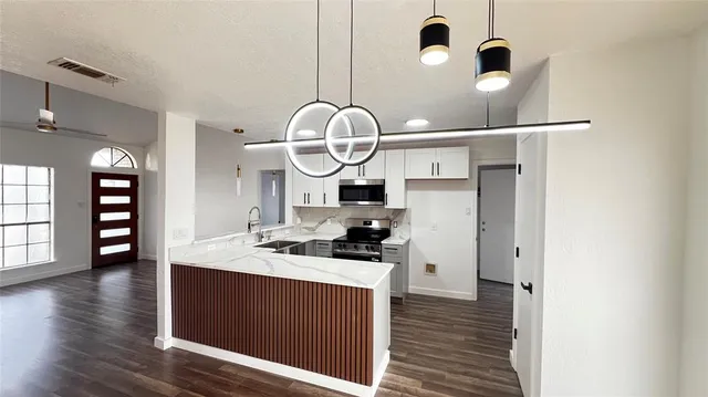 a kitchen with a sink cabinets and wooden floor