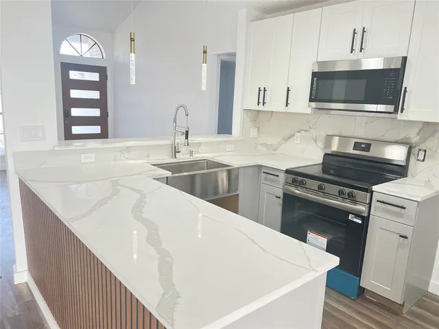 a kitchen with a sink stove and microwave