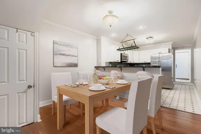 a dining area with stainless steel appliances kitchen island a table and chairs