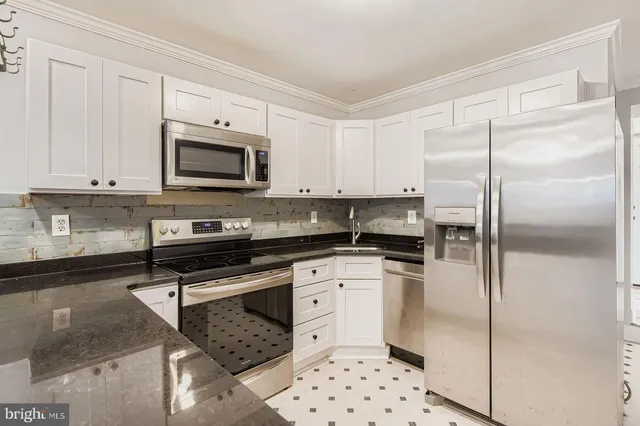 a kitchen with stainless steel appliances a refrigerator sink and microwave