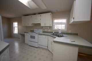 1580 Turner Branch Road Goodview, VA 24095 - Photo 9 of 19 a kitchen with granite countertop white cabinets and white appliances