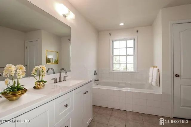 a bathroom with a sink mirror and a bathtub
