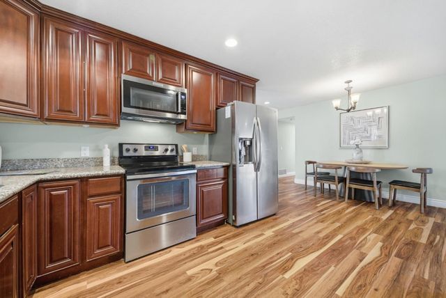 a kitchen with stainless steel appliances granite countertop a refrigerator stove top oven and sink