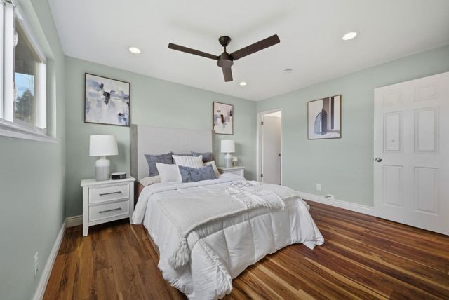 a bedroom with a bed and wooden floor