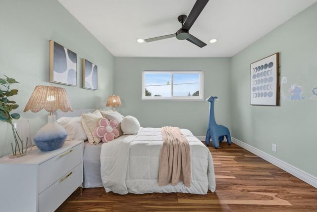 a bedroom with bed and wooden floor