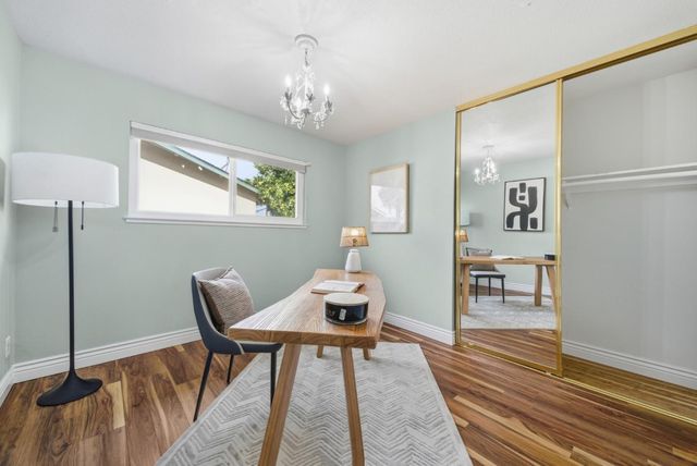 a workspace with wooden floor and a chandelier