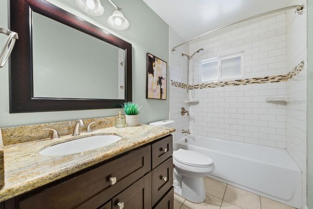 a bathroom with a granite countertop sink a toilet and a bathtub