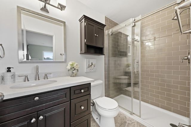 a bathroom with a sink a toilet and shower