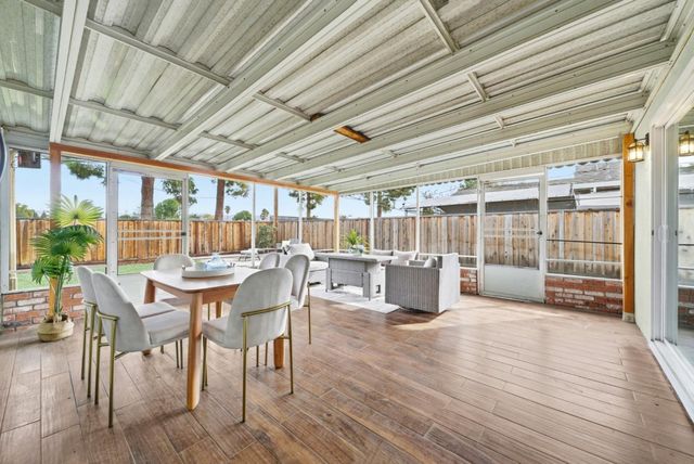 a view of a patio with table and chairs with wooden floor and fence