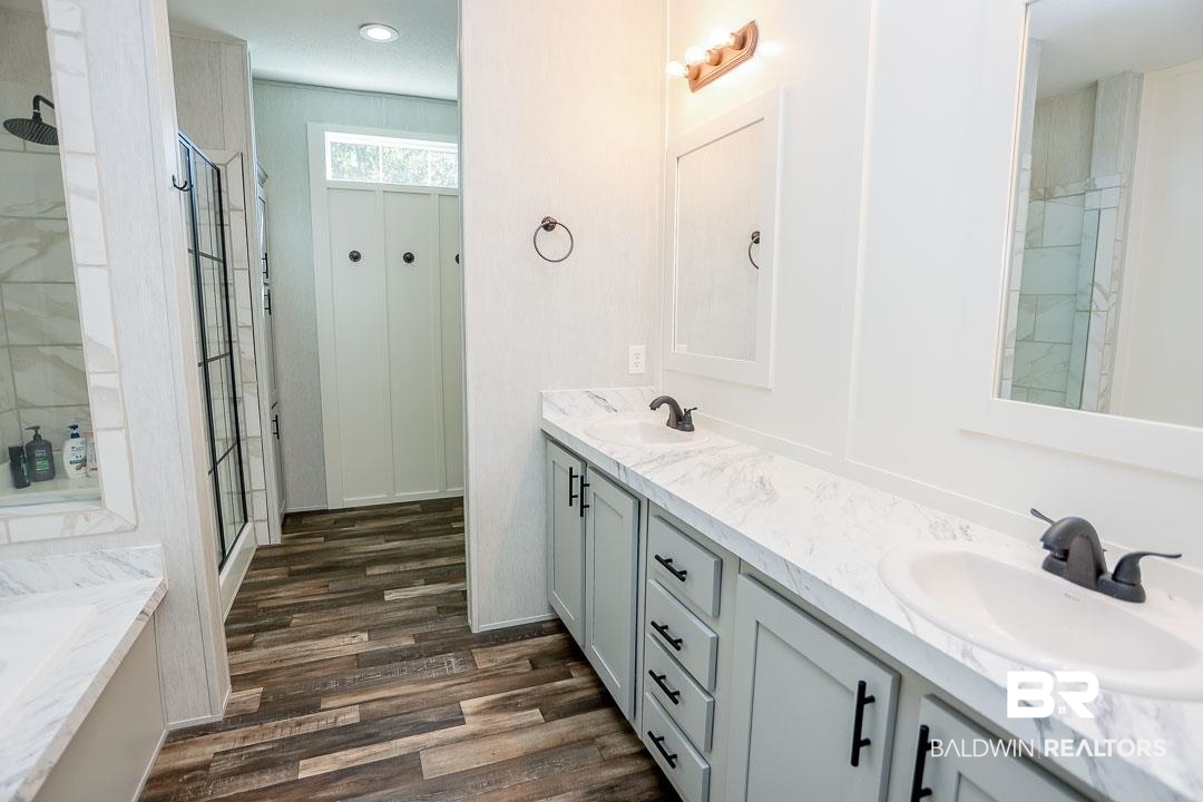 19180 Horseshoe Circle Seminole, AL 36574 - Photo 25 of 38 Bathroom with double vanity, dark wood-style flooring, a bath, and a stall shower
