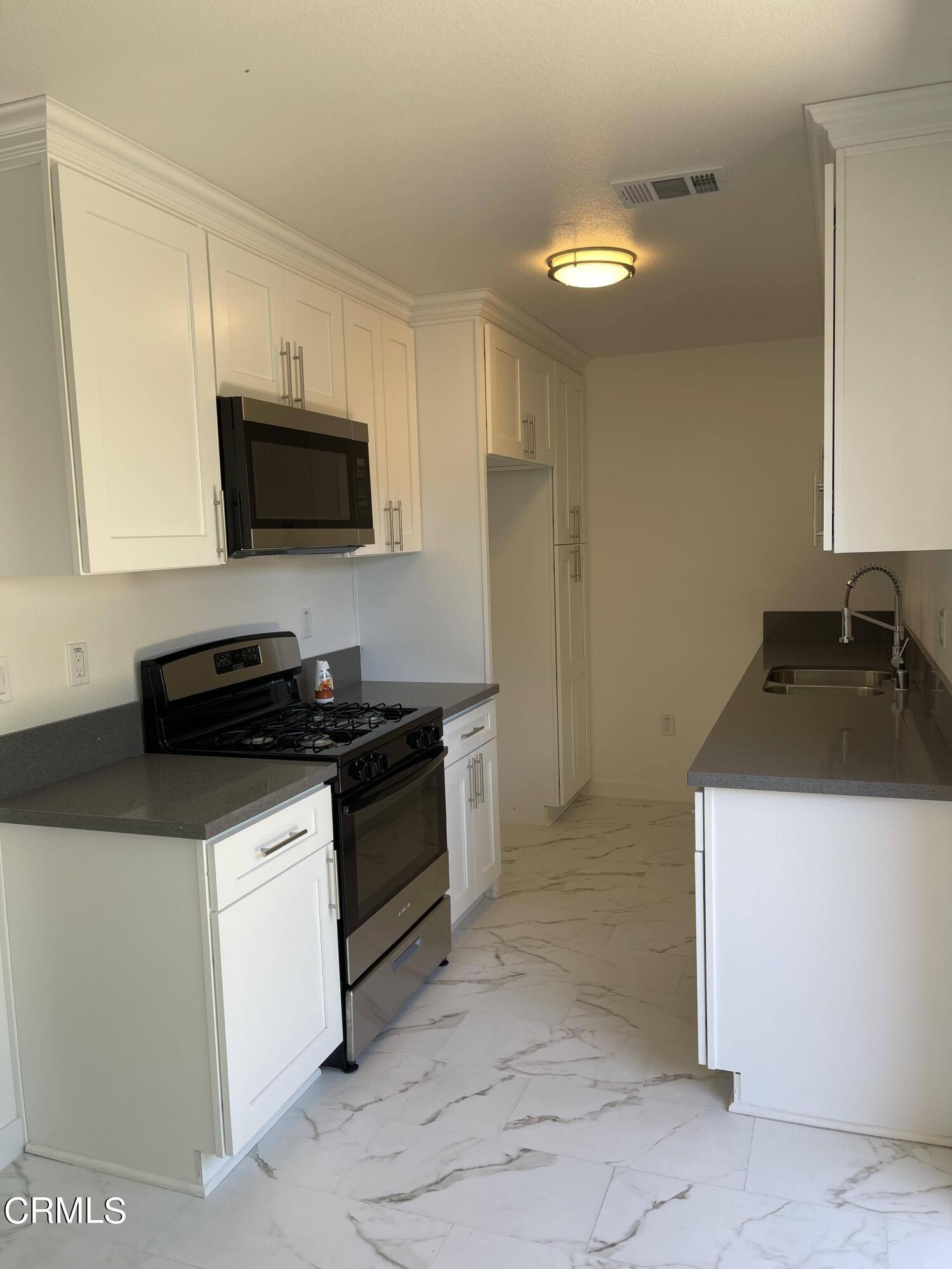 3042 Concord Drive, Unit 34 Oxnard, CA 93033 - Photo 4 of 8 a kitchen with a sink and a stove top oven