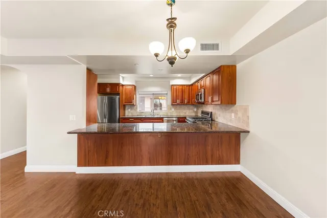 a kitchen with granite countertop a sink cabinets and stainless steel appliances