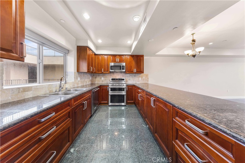 11218 Camarillo Street, Unit 404 Toluca Lake, CA 91602 - Photo 21 of 53 a large kitchen with stainless steel appliances granite countertop plenty wooden cabinets
