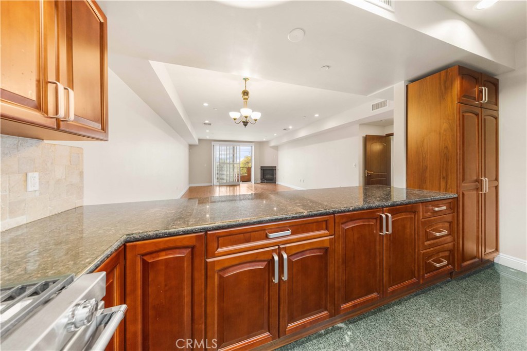 11218 Camarillo Street, Unit 404 Toluca Lake, CA 91602 - Photo 22 of 53 a kitchen with stainless steel appliances granite countertop a sink and a granite counter tops