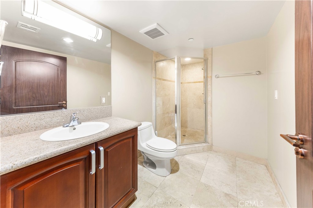 11218 Camarillo Street, Unit 404 Toluca Lake, CA 91602 - Photo 28 of 53 a bathroom with a sink a toilet a mirror and shower