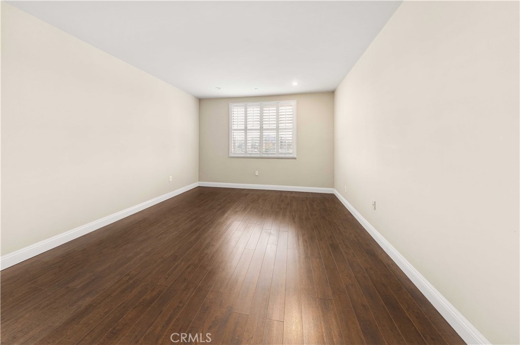 11218 Camarillo Street, Unit 404 Toluca Lake, CA 91602 - Photo 31 of 53 an empty room with wooden floor and windows