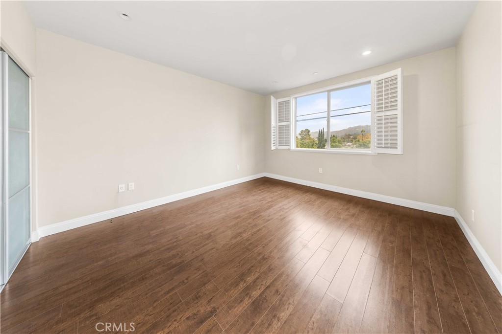 11218 Camarillo Street, Unit 404 Toluca Lake, CA 91602 - Photo 32 of 53 wooden floor in an empty room with a window