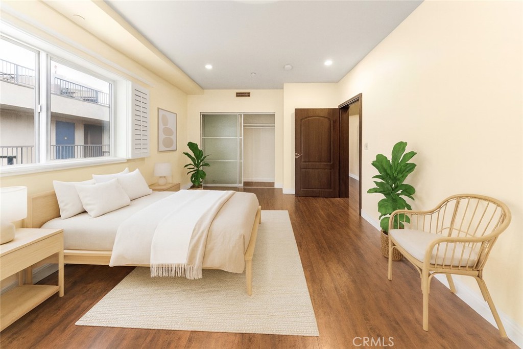 11218 Camarillo Street, Unit 404 Toluca Lake, CA 91602 - Photo 38 of 53 a large bedroom with a bed and wooden floor
