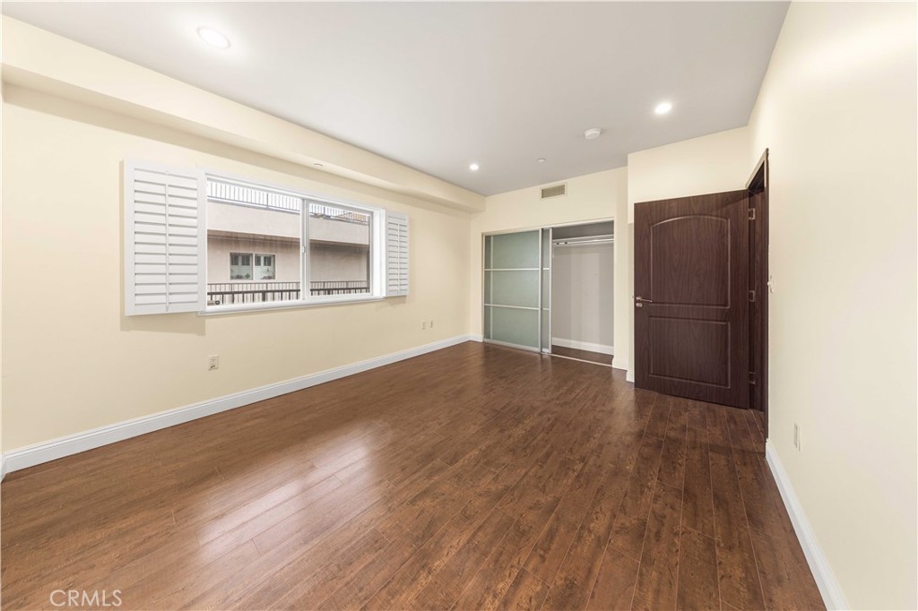 11218 Camarillo Street, Unit 404 Toluca Lake, CA 91602 - Photo 39 of 53 a view of an empty room with wooden floor and a window