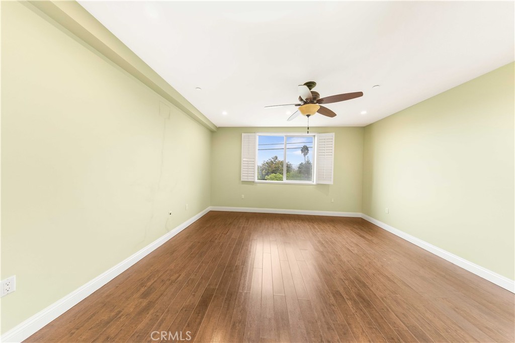 11218 Camarillo Street, Unit 404 Toluca Lake, CA 91602 - Photo 40 of 53 an empty room with wooden floor and windows