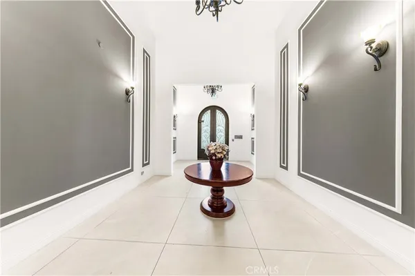 a view of an empty room with a fireplace and a chandelier