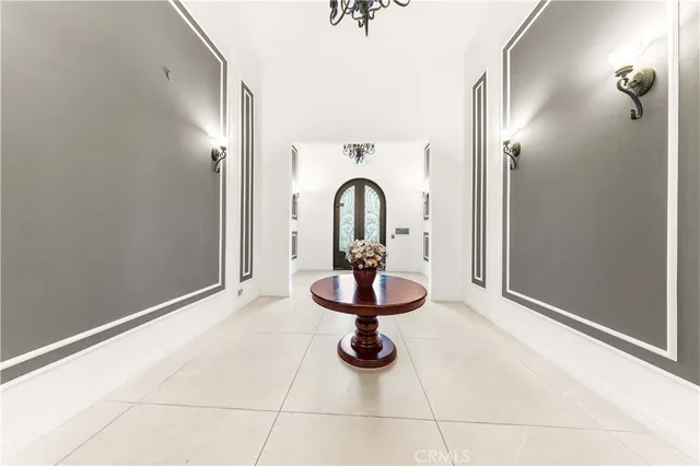 a view of an empty room with a fireplace and a chandelier