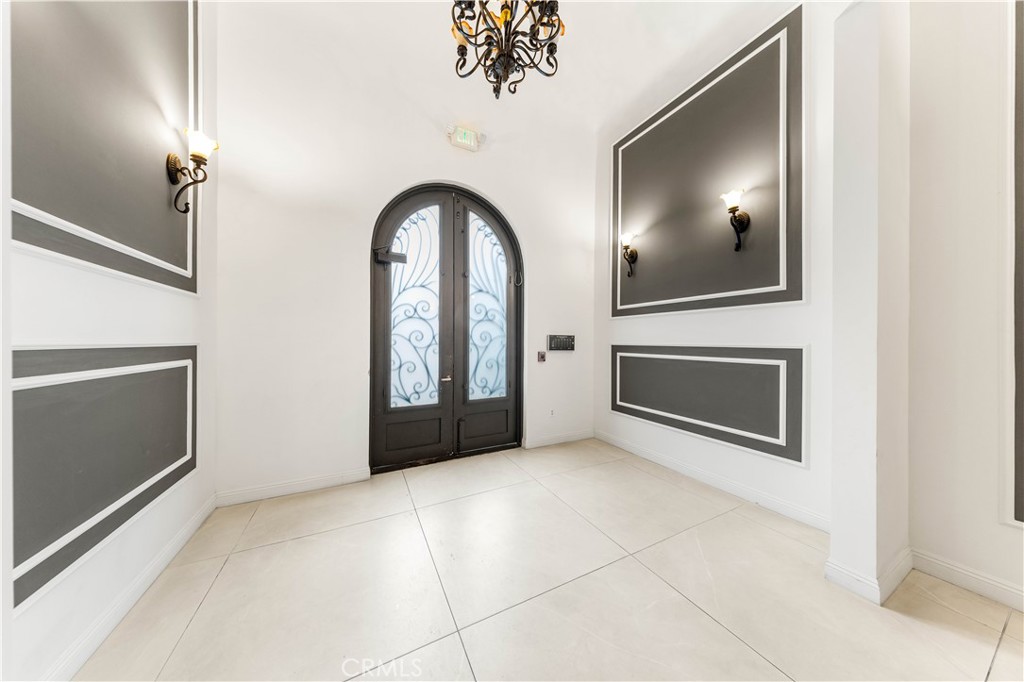 11218 Camarillo Street, Unit 404 Toluca Lake, CA 91602 - Photo 5 of 53 a view of an empty room with a fireplace and a chandelier