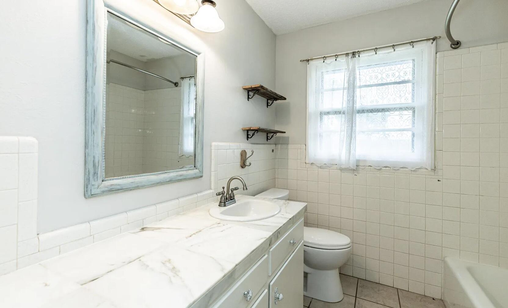 5424 14th Street Lubbock, TX 79416 - Photo 16 of 20 a bathroom with a sink toilet and shower