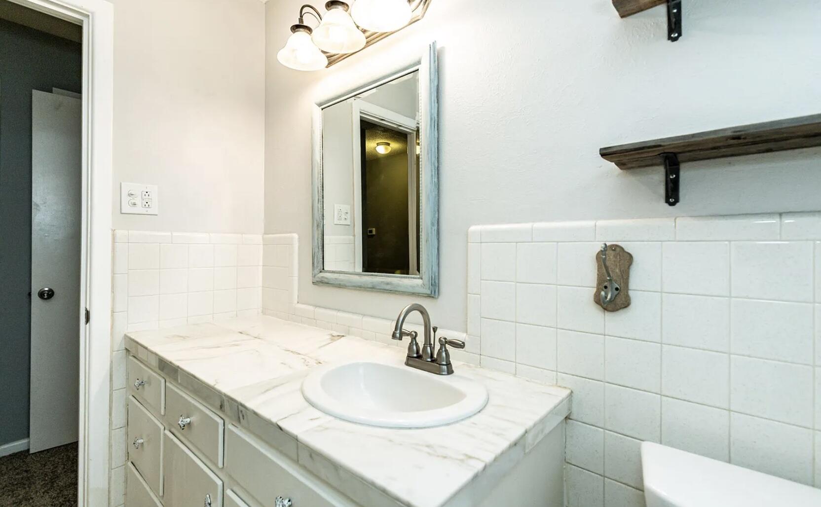 5424 14th Street Lubbock, TX 79416 - Photo 17 of 20 a bathroom with a sink and a mirror