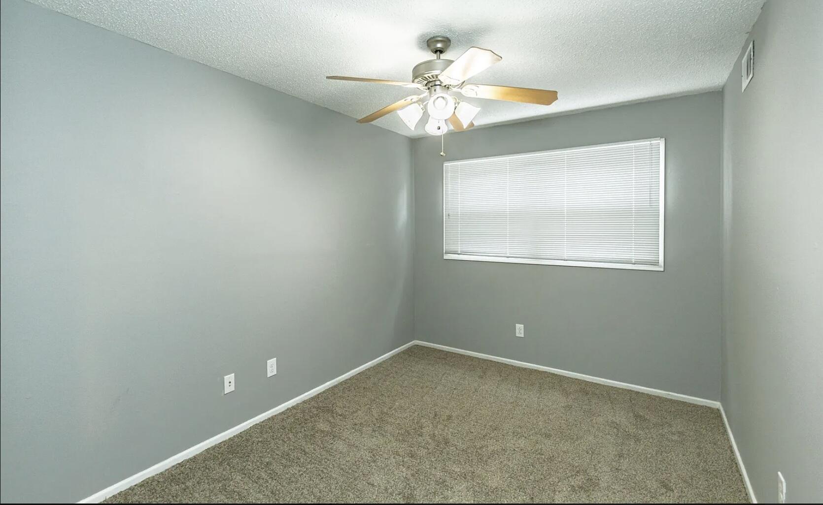 5424 14th Street Lubbock, TX 79416 - Photo 18 of 20 an empty room with a chandelier fan and windows