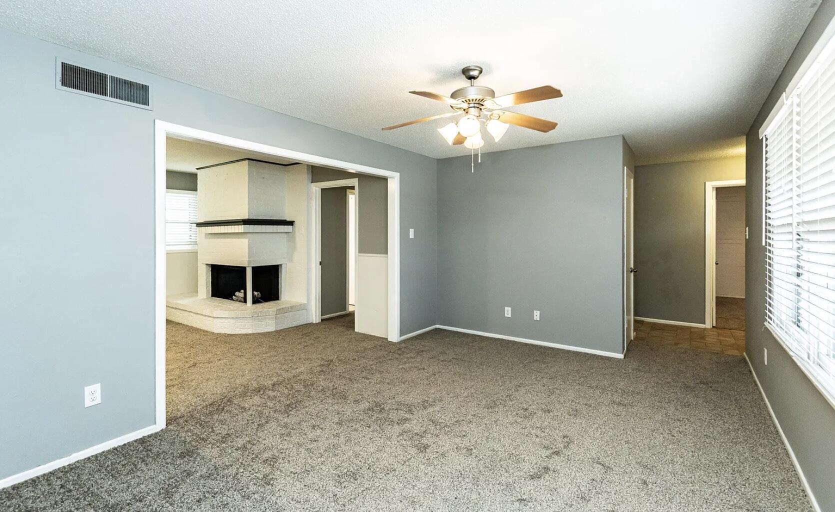 5424 14th Street Lubbock, TX 79416 - Photo 2 of 20 an empty room with windows and fireplace