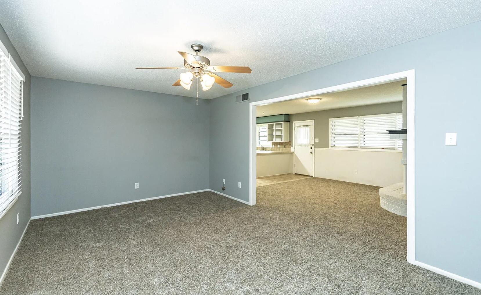 5424 14th Street Lubbock, TX 79416 - Photo 6 of 20 an empty room with windows and chandelier fan