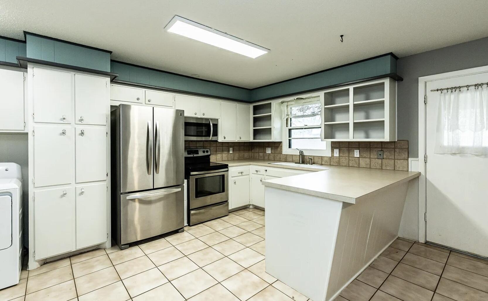 5424 14th Street Lubbock, TX 79416 - Photo 7 of 20 a kitchen with granite countertop a refrigerator stove top oven and sink
