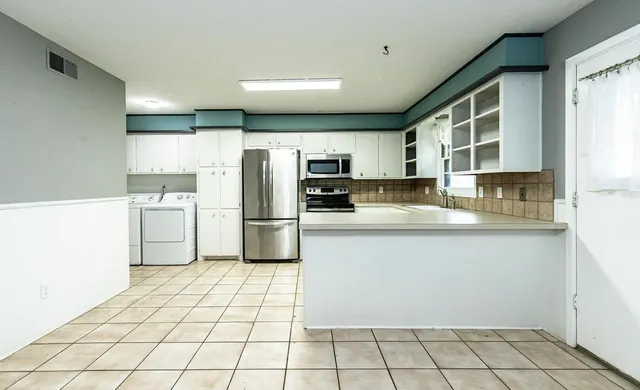 a kitchen with stainless steel appliances a refrigerator sink microwave and cabinets