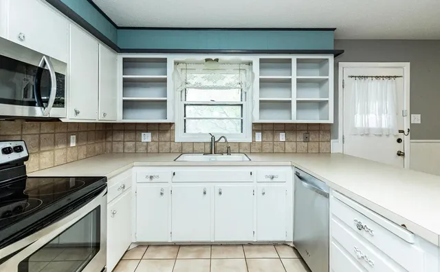 a kitchen with a sink stove top oven and cabinets