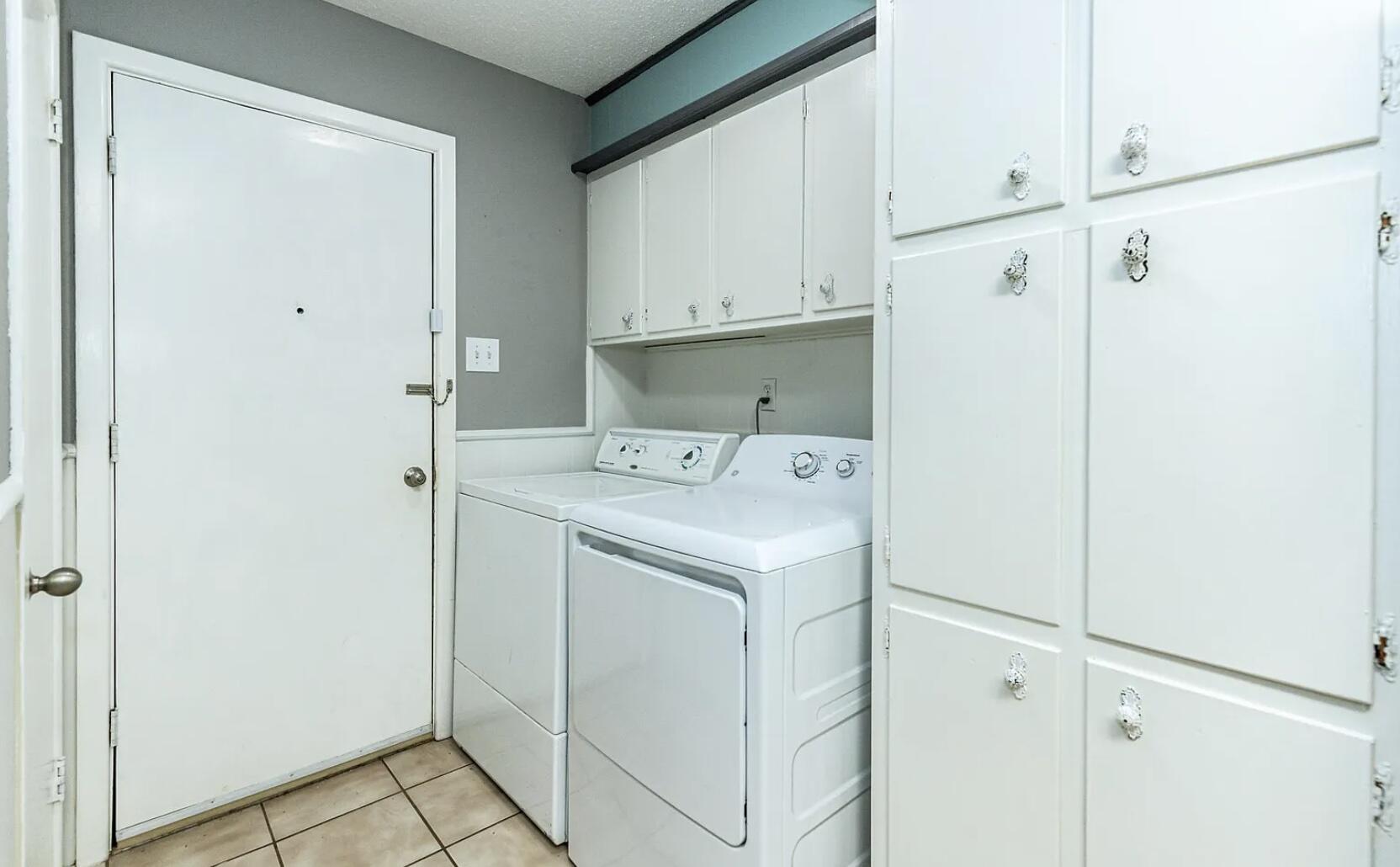 5424 14th Street Lubbock, TX 79416 - Photo 10 of 20 a utility room with cabinets washer and dryer