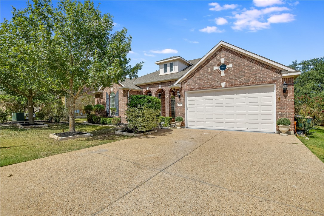 front view of house with a yard and trees