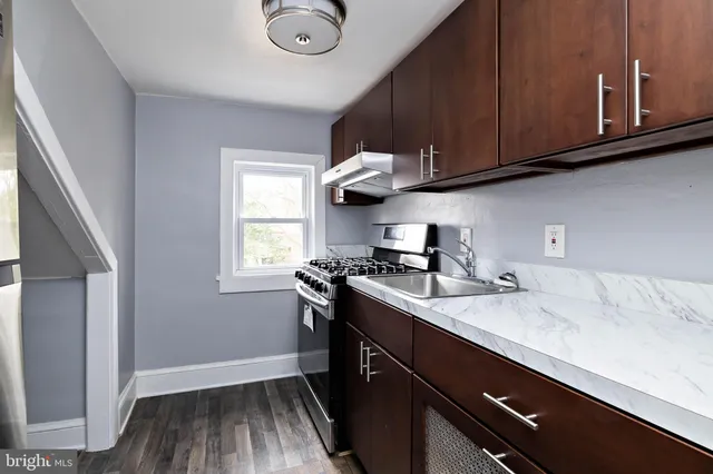 a kitchen with stainless steel appliances granite countertop a sink stove and cabinets