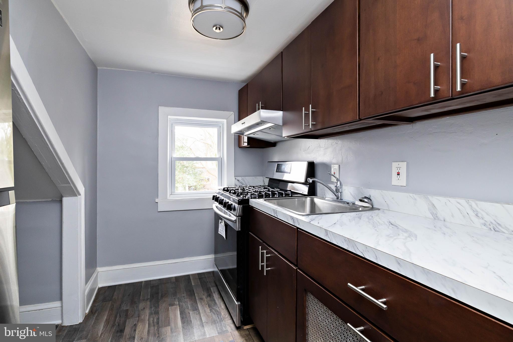 20 East Merchant Street, Unit C Audubon, NJ 08106 - Photo 19 of 26 a kitchen with stainless steel appliances granite countertop a sink stove and cabinets