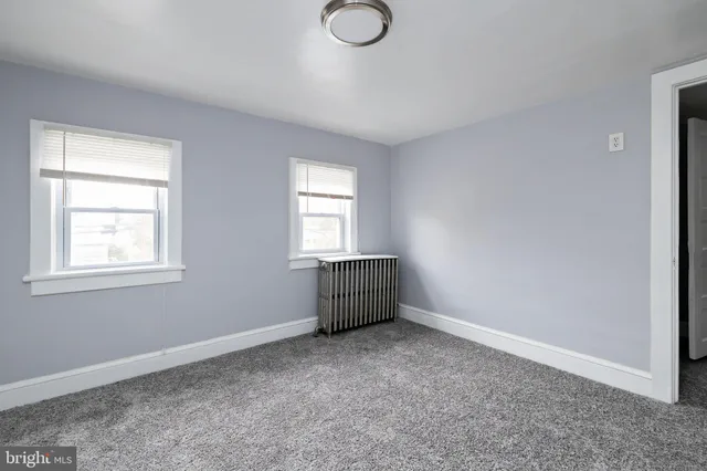 an empty room with windows and closet