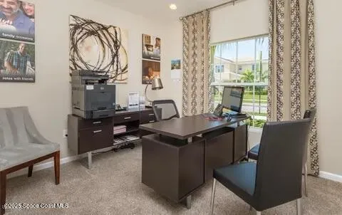 a view of a workspace with furniture and a window