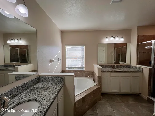 a spacious bathroom with a granite countertop sink and a large mirror