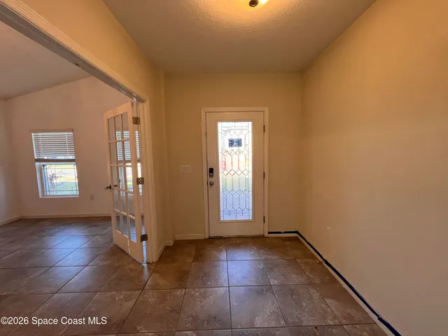 a view of a hallway with wooden floor and windows