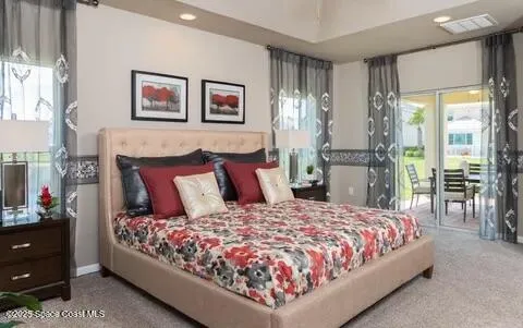 a large bed sitting in a bedroom next to a window with a lamp and a table