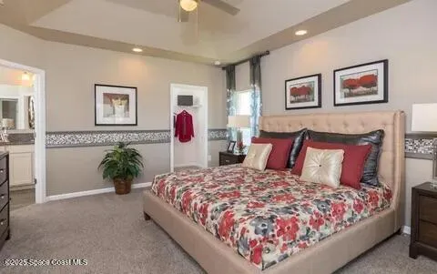 a bed sitting in a bedroom next to a window and a potted plant