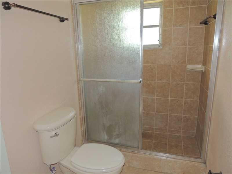 4112 Inverrary Drive, Unit 13F Lauderhill, FL 33319 - Photo 7 of 13 a white toilet sitting next to a shower
