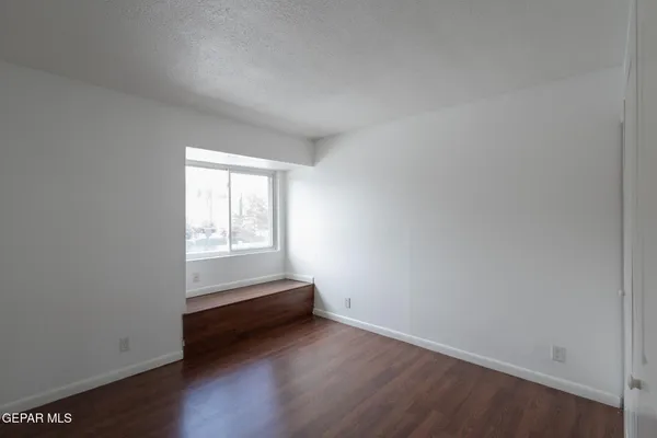a view of room with window and wooden floor