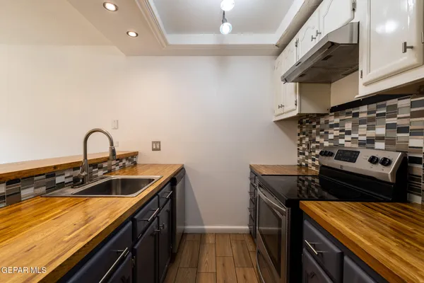 a kitchen with a sink and a stove top oven