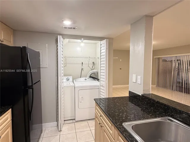 a kitchen with a refrigerator and a sink
